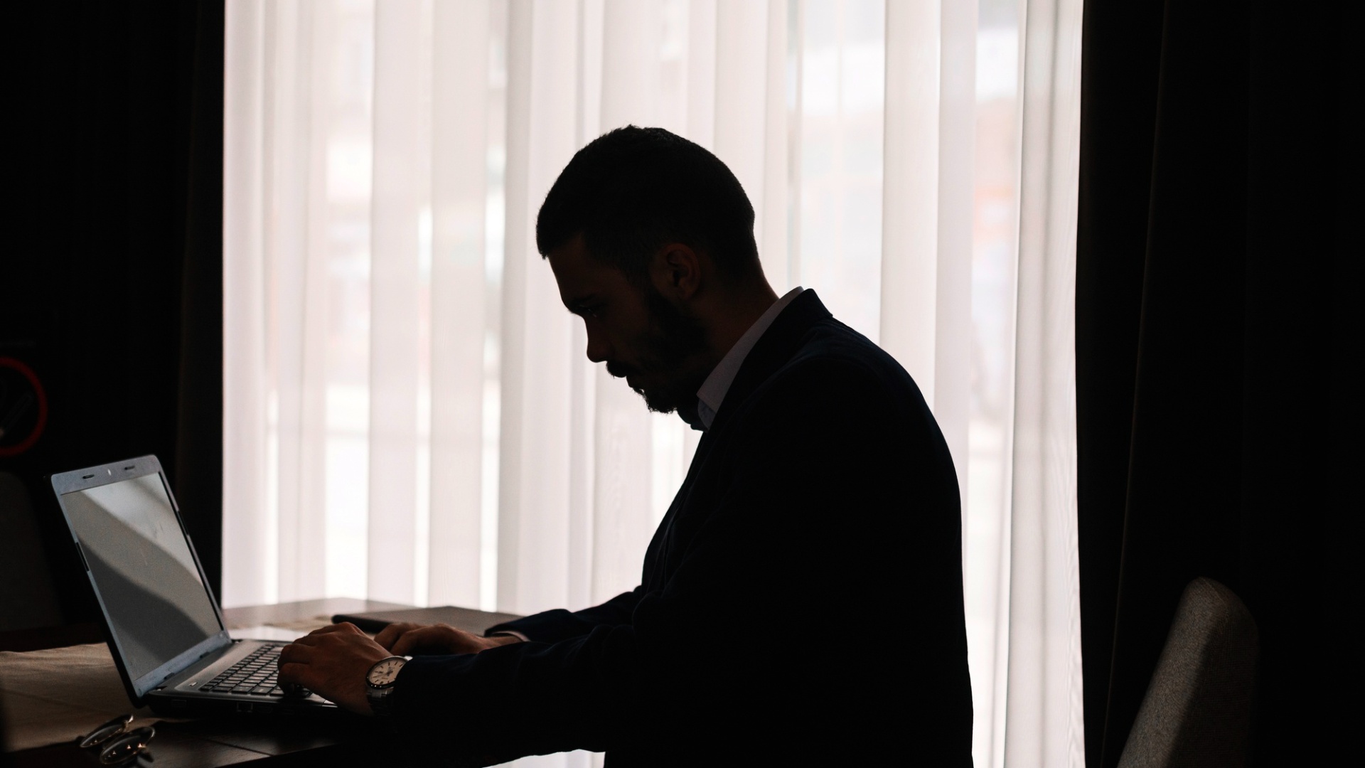 Mørk skygge foran en computerskærm, symbol på skjult afhængighed, afhængigheden bliver afsløret, dansk sexolog center, misbrugsskolen.dk,